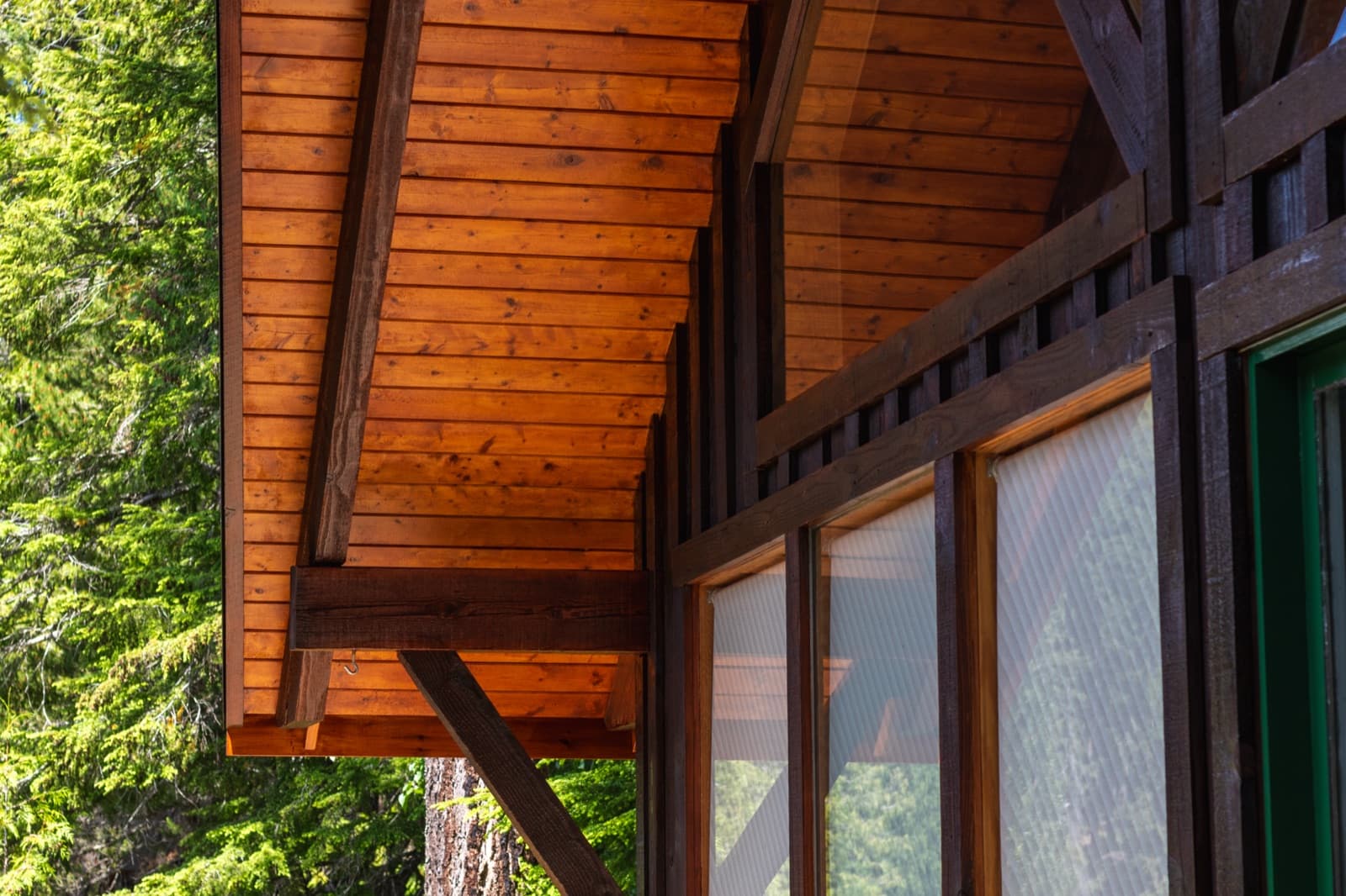 Freshly refinished tongue-and-groove cedar soffit with dark timber trim, Whistler